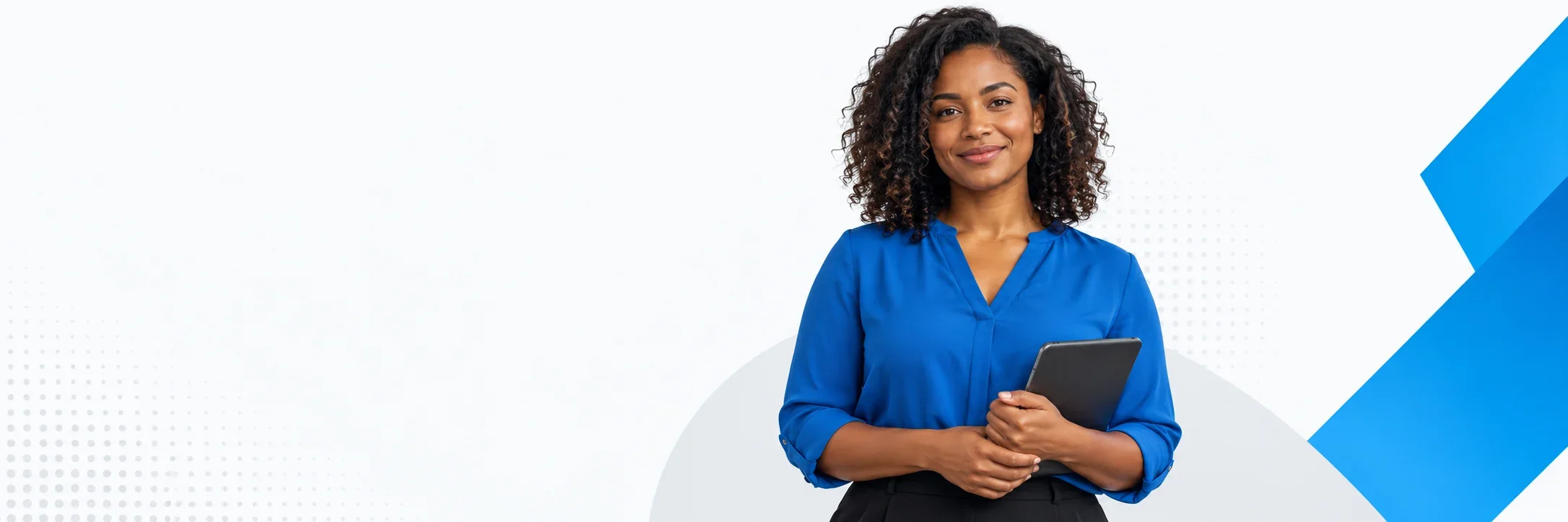 Profissional sorridente, de blusa azul, com um tablet nas mãos.
